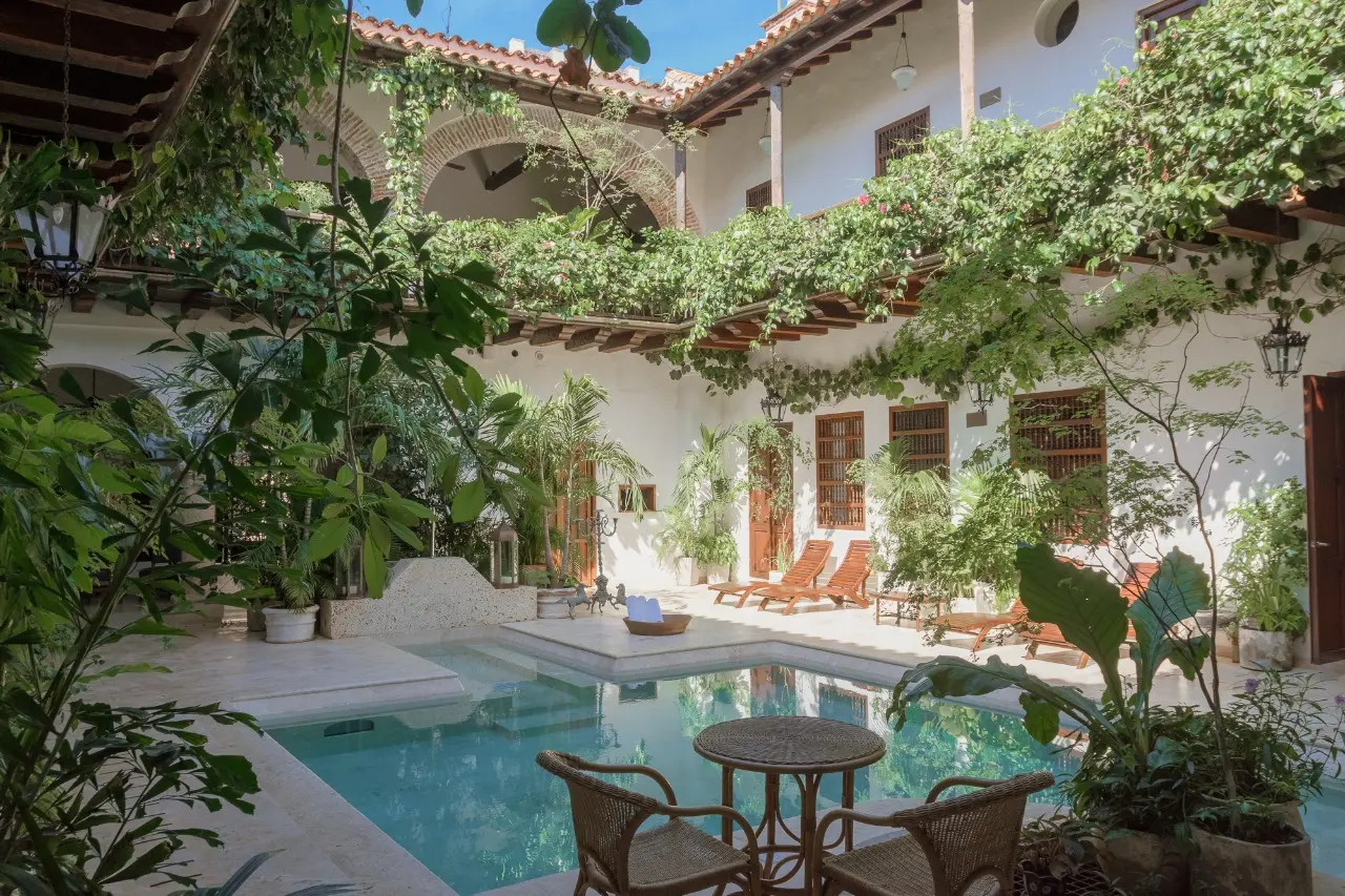 Tropical colonial courtyard pool surrounded by lush greenery at Casa Arzobispado.