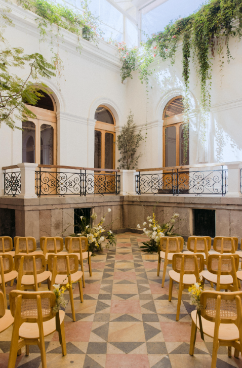 Outdoor courtyard wedding ceremony setup facing classical stone balconies at Barcelona Mexico City.