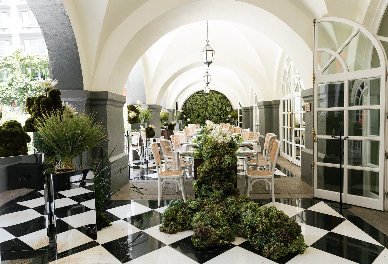 Historic white arched walkway with black and white checkered tile flooring at Four Seasons Hotel Mexico City.