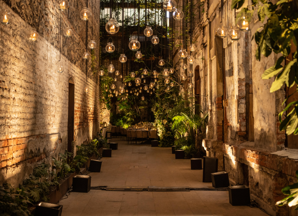 Atmospheric night wedding venue hallway lit by hanging warm round bulbs at Jardin Prim Mexico City.