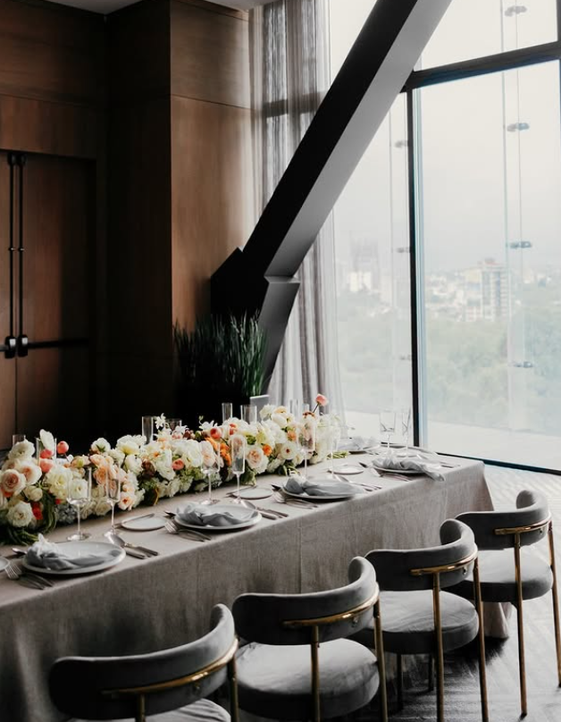 Close up of a luxury wedding reception dinner table with glowing candles and lush white flowers at The Ritz-Carlton Mexico City.