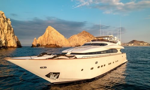 Luxurious white charter yacht navigating the ocean near the Cabo San Lucas arch at Maiora Luxury Cabo San Lucas.